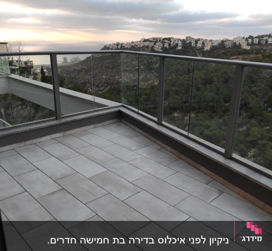 מרפסת עם רצפה נקייה ומעקה זכוכית
